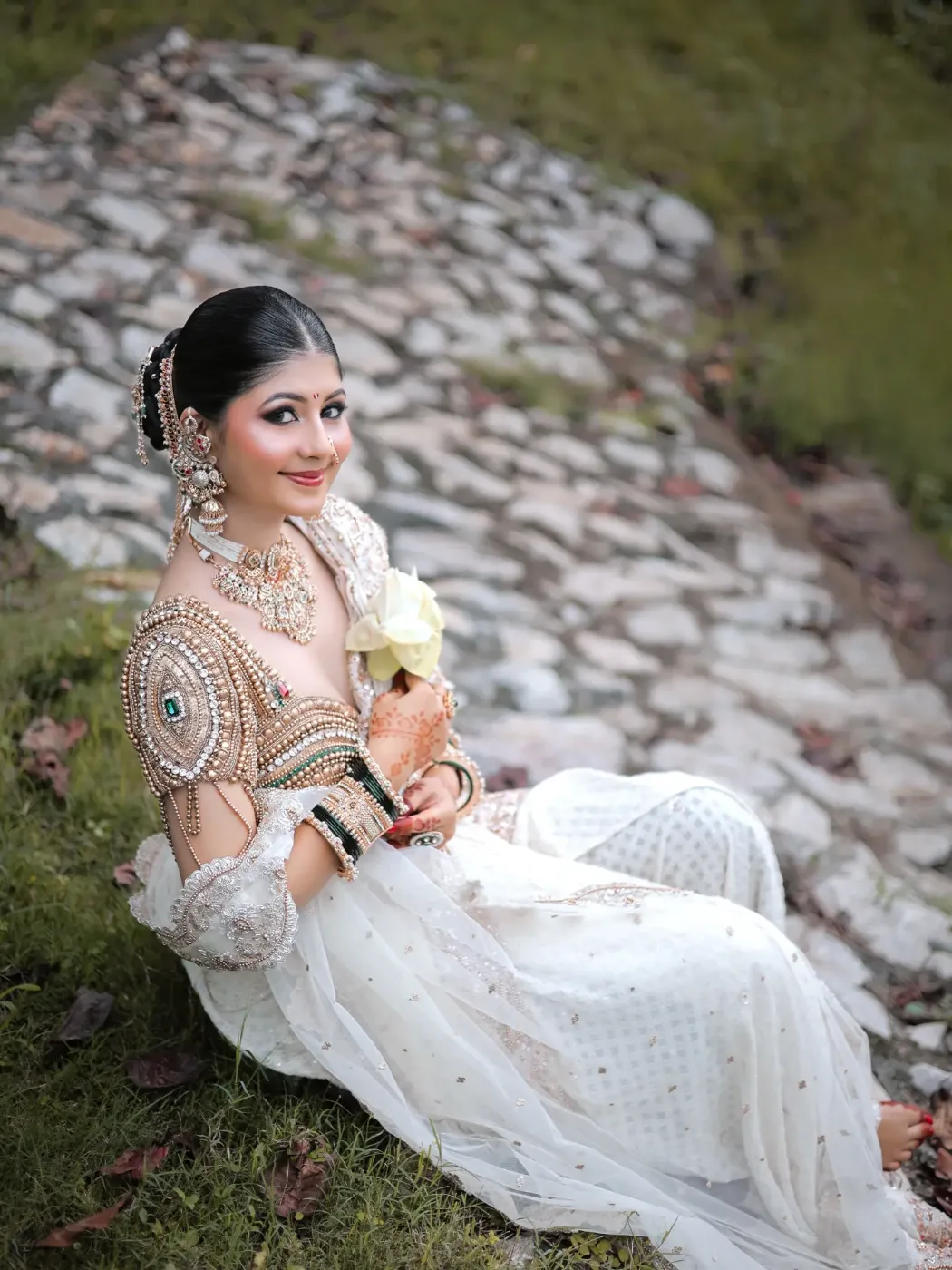 Wahi bride patthar ki path par baithi hui, haath mein safed phool